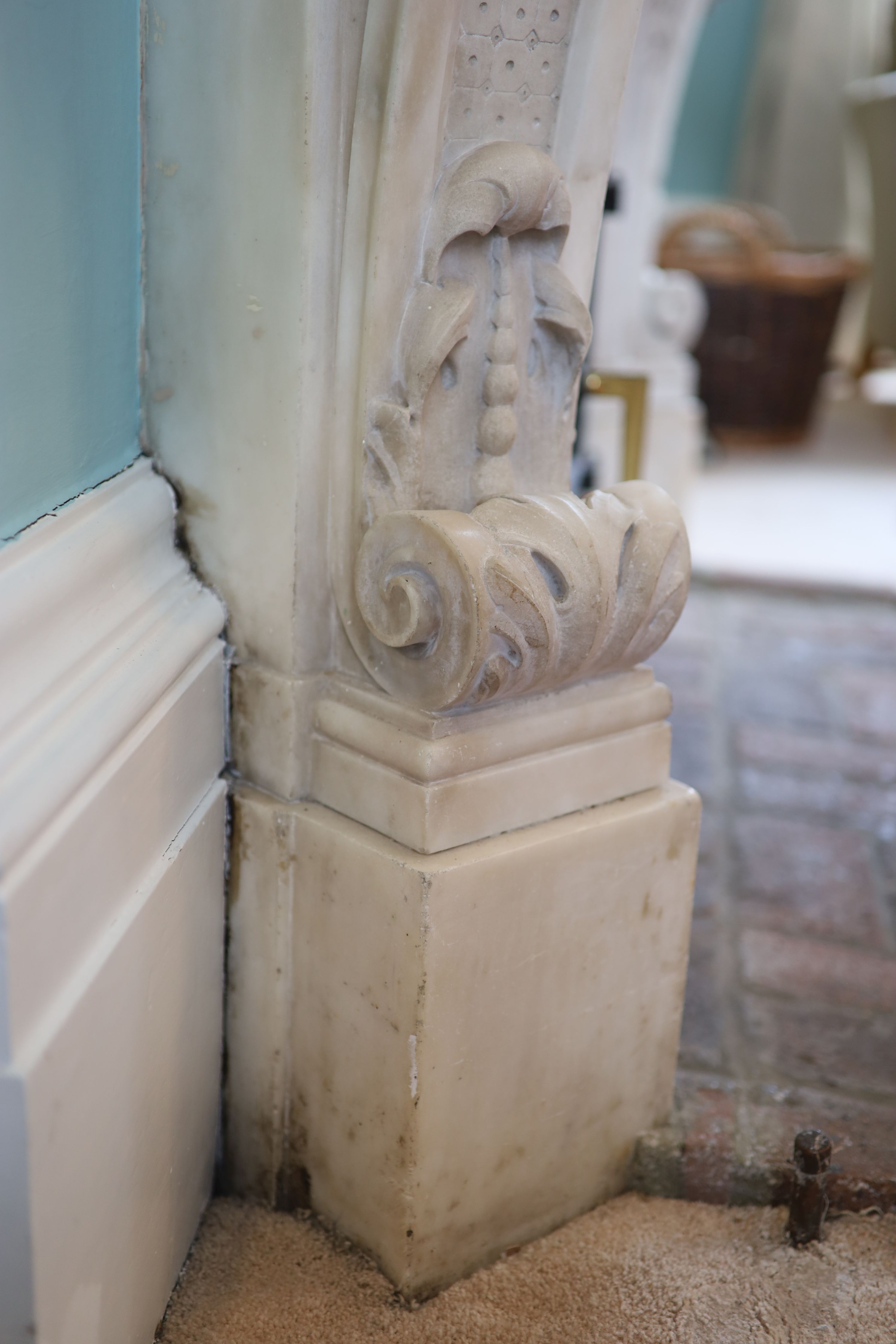 An important mid 19th century Italian white Carrara marble chimney piece, carved in the rococo taste, with seated putti, foliage swags